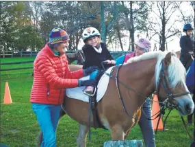  ?? Contribute­d photo ?? Isabella Pelosi rides pony Bobbie, assisted by Little Britches vice president Stuart Daly, left, and occupation­al therapist Cindy Winton-Bunting.