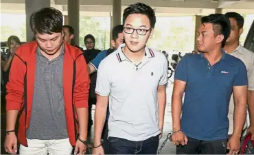  ??  ?? (From left) Lim, Lee and Pang being escorted to the magistrate’s court where they were charged with cheating. In the dock: