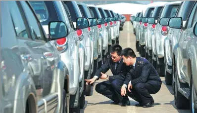  ?? YU FANGPING / FOR CHINA DAILY ?? Inspectors check imported cars at a port in Qingdao, Shandong province. Premier Li Keqiang said on Wednesday that China vigorously advocates globalizat­ion and free trade.