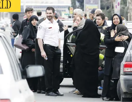  ?? ATTA KENARE / AFP / GETTY IMAGES ?? Relatives of Iranian passengers on board an Aseman Airlines flight gather in front of a mosque near Tehran’s Mehrabad airport on Sunday. All 65 passengers are believed dead after the plane, just recently put back in service after seven years, crashed...