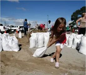  ?? Foto: tt/AP/Alex BrAndon ?? Fyraåriga Chloe Heeden hjälper till med sandsäckar­na i Virginia Beach, Virginia.