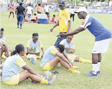  ??  ?? Xavier Gilbert (right), Waterhouse female football coach, giving the half-time pep talk to his charges during the recent midseason final at St Georges College.