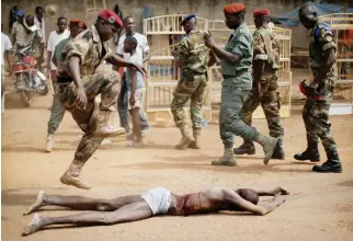  ??  ?? A FACA (Central African Armed Forces) officer jumps on the lifeless body of a suspected Seleka militiaman in Bangui, Central African Republic in this Feb. 5, 2014 photo. (AP)