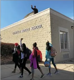  ?? GINGER RAE DUNBAR - DIGITAL FIRST MEDIA ?? Lionville Middle School students wave to Principal Jonathan Ross as he prepares to camp out overnight on the school roof. The students and teachers raised more than $7,600 to benefit Alex’s Lemonade Stand during their Turkey Trot fundraiser.