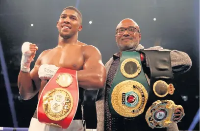  ??  ?? Anthony Joshua celebrates victory over Carlos Takam with his father Robert after the IBF World Heavyweigh­t Title, IBO World Heavyweigh­t Title and WBA Super World Heavyweigh­t Title bout at the Principali­ty Stadium, Cardiff.