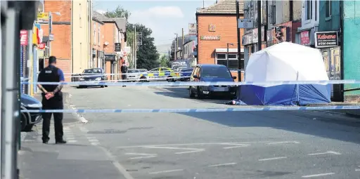  ??  ?? ●●Police cordon off Milkstone Road following the stab attack