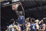  ?? Jenna Watson / Associated Press ?? UConn’s Akok Akok (11) dunks against Butler on Saturday in Indianapol­is, his first action since suffering an Achilles’ tendon injury last year.