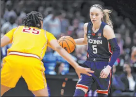  ?? Howard Lao The Associated Press ?? Uconn guard Paige Bueckers dribbles against USC guard Mckenzie Forbes during her 28-point performanc­e in an 80-73 win.