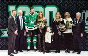  ?? (AP Photo/emil T. Lippe) ?? Dallas Stars left wing Jamie Benn (14) poses for a photo his family and Stars President Brad Alberts, left, general manager Jim Nill, second from left, prior to an NHL hockey game Saturday in Dallas. Benn’s fiancee Jessica Bennett, fourth from left, niece Sophia Benn, fourth from right, sister Jenny Benn, third from right, and parents Heather, second from right, and Randy Benn, right, also pose.