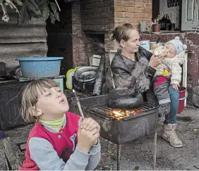  ?? EVGENIY MALOLETKA THE ASSOCIATED PRESS FILE PHOTO ?? Margaryta Tkachenko feeds her nine-month-old daughter Sophia on Sept. 25 in the liberated town of Izium, Ukraine. Fred Witteveen discusses how children being traumatize­d by the war in Ukraine continue to need Canada’s help.