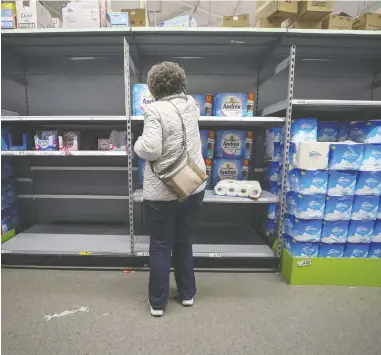  ?? CHRIS RATCLIFFE / BLOOMBERG ?? The shelves in some stores, such as this one in Wheatly, U.K., have become increasing­ly bare as consumers start
hoarding groceries and hygiene products amid fears of shortages because of the spreading coronaviru­s.