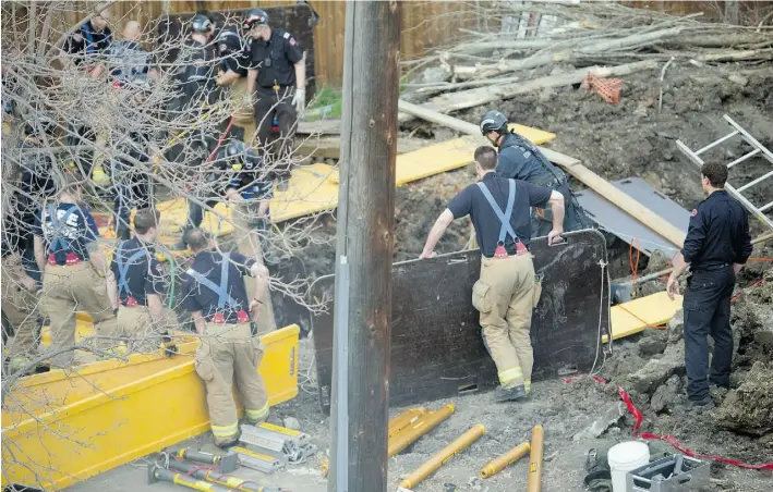  ?? BRUCE EDWARDS/ EDMONTON JOURNAL ?? Firefighte­rs work to recover a worker buried under clay and dirt when a trench collapsed at 108th Avenue and 123rd Street on Tuesday.