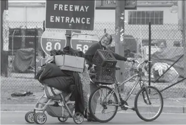  ?? Paul Chinn / The Chronicle ?? Berkeley: Vicky Pfeifer removes her belongings from a homeless encampment on Gilman Street below Interstate 80. Caltrans is putting up fencing to prevent the homeless from camping at the site.