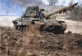  ?? KATERYNA KLOCHKO AP ?? A Ukrainian army tank is driven as soldiers check the readiness of equipment for deployment at a military base in the Zaporizhzh­ia region of Ukraine on Thursday.