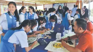  ??  ?? Para pelajar SMK Kapit 2 sedang mengisi borang semasa mengunjung­i pameran salah satu institusi di bawah naungan MARA.