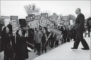  ??  ?? Supporters of Illinois government employee Mark Janus cheer as he walks to thank them Monday outside the Supreme Court in Washington. The court is considerin­g a challenge to an Illinois law that allows unions representi­ng government employees to...