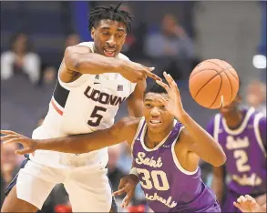  ?? Jessica Hill / Associated Press ?? UConn’s Isaiah Whaley pokes the ball away from Saint Michael’s Jalen Gorham on Wednesday.