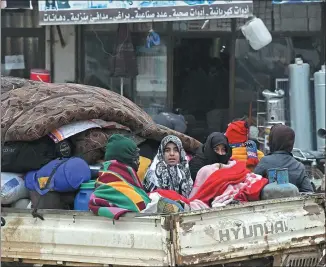  ?? RAMI AL SAYED / AGENCE FRANCE-PRESSE ?? Syrians flee violence in the town of Atme in Syria’s northweste­rn Idlib Province, near the Turkish border, on Wednesday.