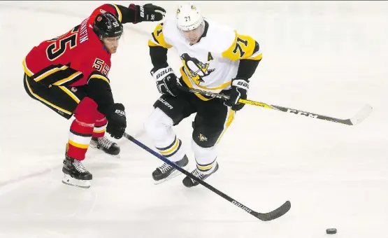  ?? DARREN MAKOWICHUK ?? Noah Hanifin and the Flames had their hands full with Evgeni Malkin and the Pittsburgh Penguins Thursday as the visitors rolled to a 9-1 win at Scotiabank Saddledome.