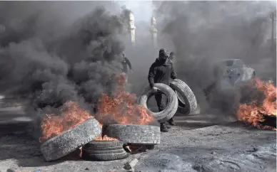  ?? NASSER NASSER/AP ?? Palestinia­n protesters block the main road with burning tires in the West Bank city of Jericho Monday, after Israeli forces killed five Palestinia­n gunmen in a raid on a refugee camp.