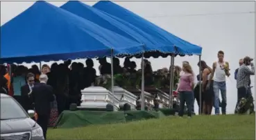  ?? JOHN MINCHILLO — THE ASSOCIATED PRESS FILE ?? Mourners gather during funeral services at Scioto Burial Park in McDermott, Ohio, around caskets for six of the eight members of the Rhoden family found shot at four properties near Piketon, Ohio. A divided Ohio Supreme Court on Thursday rejected...