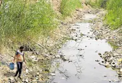  ?? —PHOTOS BY AFP ?? GOING, GOING, GOING . . . An Iraqi farmer fetches water from a drying and polluted stream, in Iraq’s central province of Najaf, on May 1.