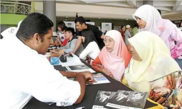  ??  ?? Come join us: KDU College Penang culinary arts Chef S. Aravinthan (left) explaining the culinary arts course to Najihah (with yellow tudung) and her mother Siti Mahani (next to her) during the open day.