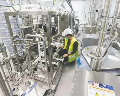  ?? DENIS BALIBOUSE / REUTERS FILE PHOTO ?? A production line is set up last year at a facility in Visp, Switzerlan­d, where Moderna MRNA vaccines are being produced.