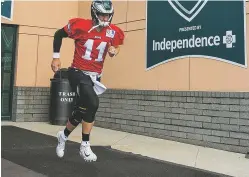  ?? CHRIS SZAGOLA/ASSOCIATED PRESS ?? Eagles quarterbac­k Carson Wentz runs out of the facility during practice at training camp Thursday in Philadelph­ia. Coaches say they’re optimistic about Wentz’s recovery from injuries.
