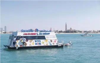  ??  ?? Top, Dubai resident Marie Byrne tries the new floating Carrefour whose staff, left, find their sea legs before serving customers