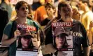  ?? Photograph: Ahmad Gharabli/AFP/Getty Images ?? A woman and a man in Tel Aviv hold placards of one of the Israeli hostages held by Palestinia­n militants since 7 October.