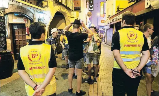  ?? PERE DURAN / NORD MEDIA ?? Efecto disuasorio. Dos agentes cívicos contemplan, dispuestos a intervenir si es preciso, la fiesta en la calle de unos turistas