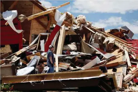  ?? REUTERS PIC ?? A man looking through debris in Canton, Texas, on Sunday.