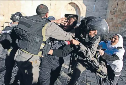  ?? Photos: REUTERS ?? Hands-on treatment: Israeli border police scuffle with Palestinia­n medics, centre and right, during clashes at a protest outside Jerusalem’s Old City. The protest came after the death of Maysara Abu Hamdeya, a Palestinia­n inmate who died from cancer in...