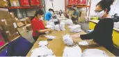  ?? CURTIS COMPTON / POSTMEDIA NEWS VIA AP ?? Workers pack face masks at a facility in Georgia. There is increasing evidence that near-universal mask use could
do much to contain the virus as lockdowns are eased.
