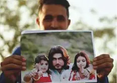  ?? AFP ?? A Pakistani protester holds a photograph of 23-year-old Naqeebulla­h Mehsud, during a protest in Karachi. The killing of the young social media star has uncorked festering anger.