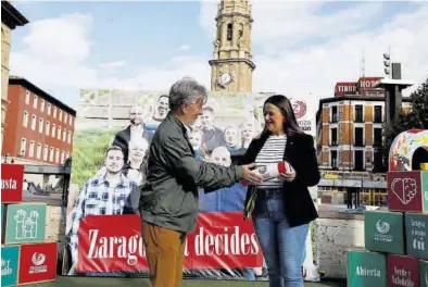 ?? ANDREEA VORNICU ?? Pedro Santisteve entrega el testigo simbólico a Elena Tomás, ayer en la plaza del Pilar.