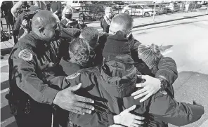  ?? MARK ZALESKI/ USA TODAY NETWORK ?? Nashville Metro Police Chief John Drake, left, and officers Amanda Topping, Michael Sipos, James Luellen, Brenna Hosey and James Wells spend a moment in a group hug after a news conference on Sunday, the day after the explosion in downtown.