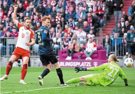  ?? ?? Record-setter: Bayern’s harry Kane (left) scores his side’s third goal during the Bundesliga match against Mainz. — ap