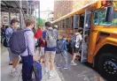  ?? RICHARD DREW/ASSOCIATED PRESS ?? Students board a school bus in New York City in September. Late school buses, virus exposures and quarantine­s are among the disruption­s to learning.