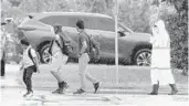  ?? CARLINE JEAN/SOUTH FLORIDA SUN SENTINEL ?? A school crossing guard helps students cross the street as they head out from the first day back to school at Boca Raton Elementary school in Boca Raton.