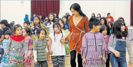  ?? LILLIAN SWAIN ?? Students from Sakatchewa­y Anishinabe School in Grassy Narrows kick off their school year in style with principal Sharon Lee at a welcome back powwow.