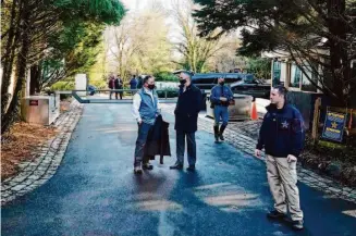  ?? Patrick Semansky/Associated Press 2021 ?? Security personnel gather at the entrance to President Biden’s home in Wilmington, Del., in 2021. Six pages of classified documents have been found in a search of Biden’s private library.