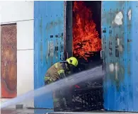  ?? Photo by Dhes Handumon ?? A firefighte­r battles fire as it engulfs a warehouse in Sharjah Industrial Area 13 on Monday. Officials say the fire caused loss worth millions of dirhams. —