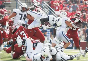  ?? Gary Kazanjian / Associated Press ?? UConn running back Kevin Mensah goes up high for a short gain against Fresno State on Saturday in Fresno, Calif.