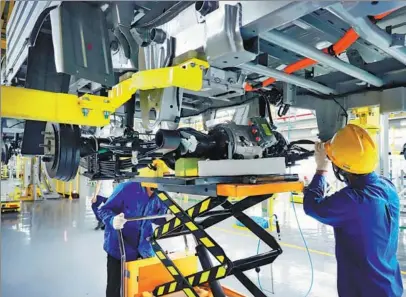  ?? PROVIDED TO CHINA DAILY ?? Wuling employees work on an electric truck assembly line in Liuzhou, the Guangxi Zhuang autonomous region.