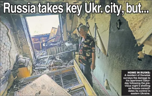  ?? ?? HOME IN RUINS: A resident of Donetsk surveys the damage to his apartment Saturday following the previous night’s shelling as Russia consolidat­es its control in eastern Ukraine.