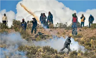  ?? PHOTOS: REUTERS ?? An independen­t miner returns a tear gas capsule during clashes with riot police during a protest against Bolivia’s President Evo Morales’ government policies, in Panduro south of La Paz.
