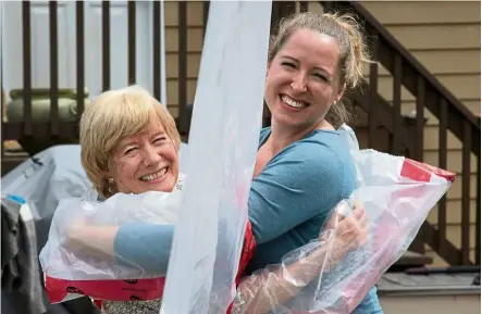  ?? — aFP ?? Next best thing: ellis (right) hugging her mother susan Watts using the ‘hug glove’ that ellis and her husband created as a Mother’s day gift in Guelph, Ontario.