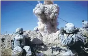  ?? MICHAEL KAMBER/THE NEWYORK TIMES ?? U.S. soldiers look on after detonating explosives to destroy a Taliban bunker spotted earlier by helicopter­s in Kandahar Province, Afghanista­n, in 2011.